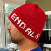 Red hand knit hat with "End ALS" in white letters on the brim is shown modeled on a man with dark stubble.